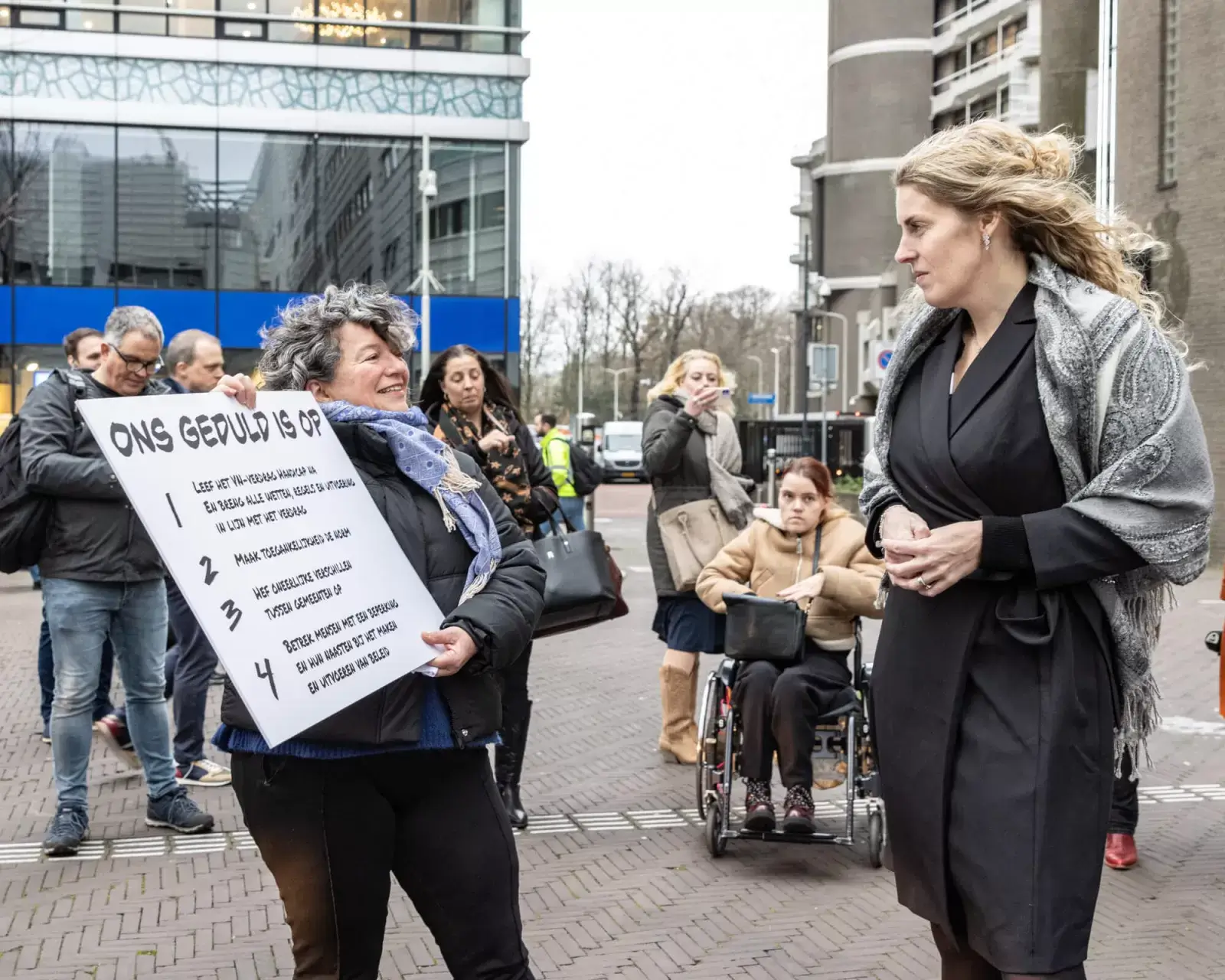 Illya Soffer biedt een protestbord aan aan staatssecretaris Maeijer.