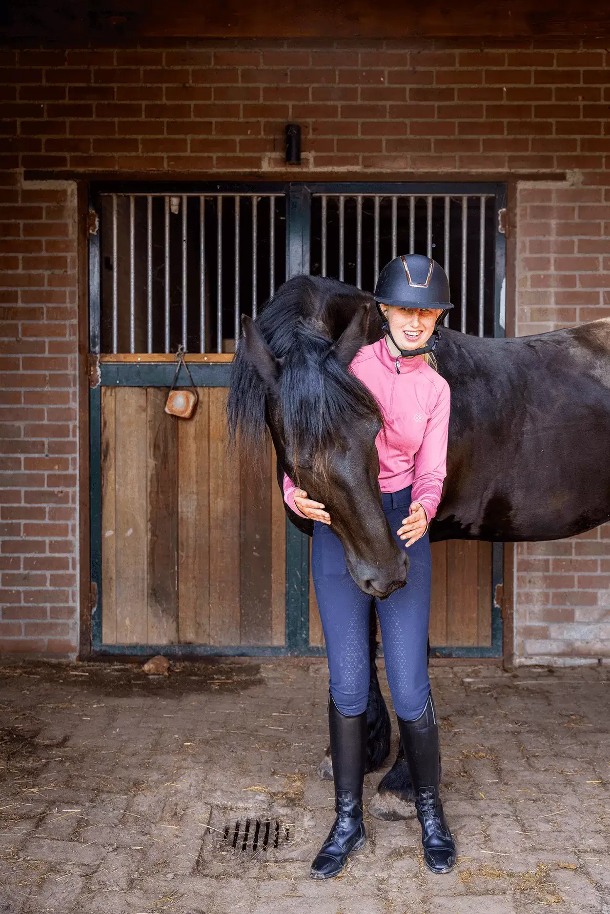 Anne met haar paard in de stal.